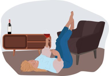 Neşeli pozitif kadın evde eğlenirken şarap içiyor. Yerde yatan ve elinde bir bardak şarap tutan kız..