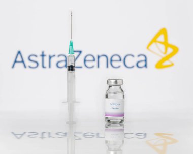 Teo, İspanya; 25 Ocak 2021: AstraZeneca Covid-19 aşı konsepti. Arka planda bir şırınga ve AstraZeneca şirketinin logosu bulanıklaştı..
