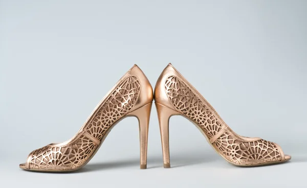 Zapatos de mujer de oro sobre fondo — Foto de Stock