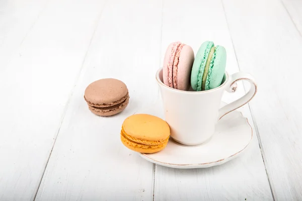 Uppsättning av macarons på vita träbord Stockbild