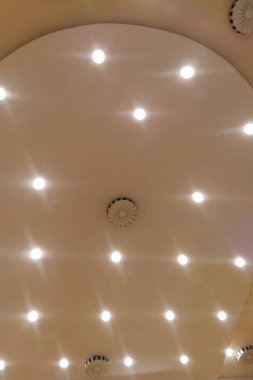 Konser salonunun tavanında lambalar açık ve yangın koruması ve havalandırma sistemi var.