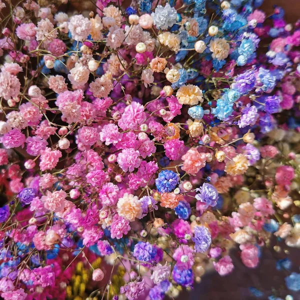 Beautiful summer small multicolored flowers in the basket. Flowers basket on the street