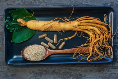 Siyah tabakta taze ginseng kökü ve kapsül ilacı için toz.
