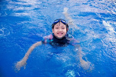 Yüzme havuzunda küçük güzel bir kız Gülümseyen ve yazın mutlu