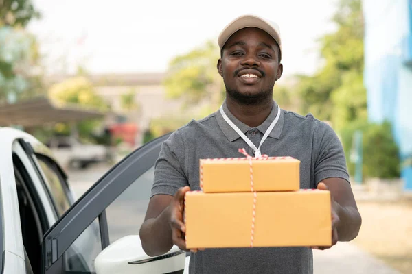 Sorriso Africano Homem Correio Entrega Masculina Frente Carro Entregando Pacote — Fotografia de Stock