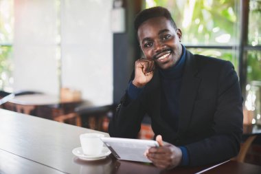 Restoranda tablet bilgisayar kullanan Afrikalı işadamı