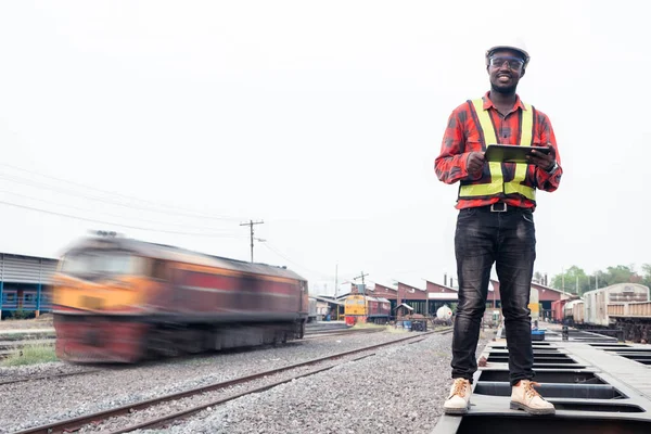 Afrikalı mühendis, treni tablet kullanarak kontrol ediyor.