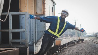 Telsiz ya da telsiz bağlantısı kuran Afrikalı mühendis trenden sarkıyor.