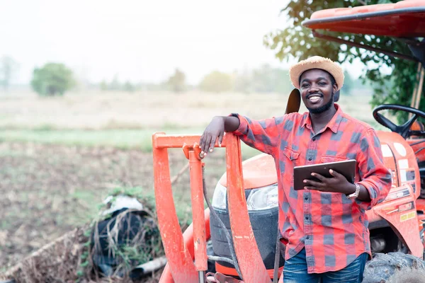 Африканский Мужчина Фермер Работает Поле Трактором Помощью Планшета — стоковое фото