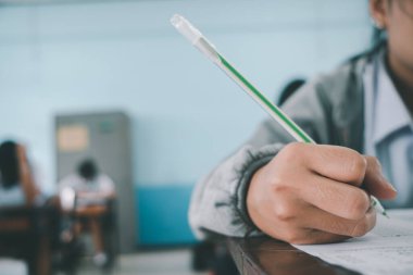 Sınav sorularını yazan ve okuyan öğrenciler, okuldaki sınav kağıtlarını stres ile okuyorlar.