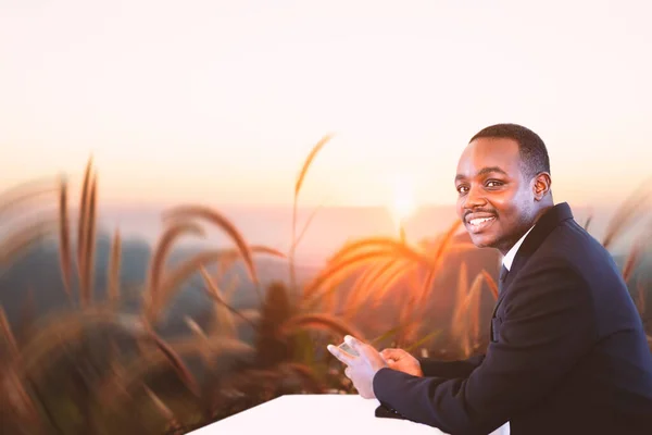 Hombre Negocios Afican Relajante Uso Teléfono Inteligente Cima Montaña Puesta —  Fotos de Stock