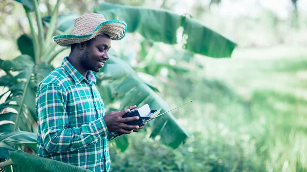 Africký Zemědělec Kloboukem Drží Retro Přijímač Stojan Banánové Plantáže Zemědělství — Stock fotografie