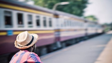 Afrikalı erkek turist tren istasyonunda tek başına tren bekliyor.