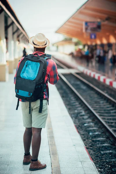 Viajero Africano Con Sombrero Mochila Usando Smartphone Esperando Tren Estación —  Fotos de Stock