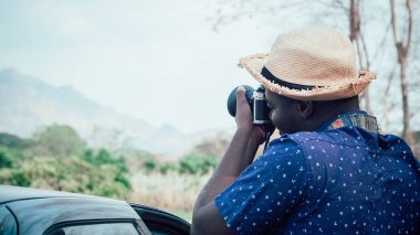 Afrikalı turistler mutlu bir şekilde dağları ve manzaraları fotoğraflıyor. Macera seyahati konsepti.
