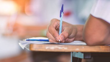 Sınav sorularını yazan ve okuyan öğrenciler, okuldaki sınav kağıtlarını stres ile okuyorlar.