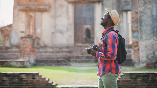 African male photographer enjoying to taking pictures of ancient scenery with beautiful old buildings