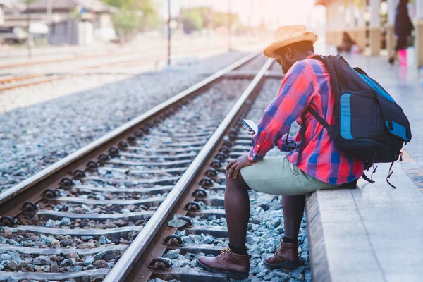 Africano Viajante Masculino Esperando Trem Estação Ferroviária Com Uso Smartphone — Fotografia de Stock