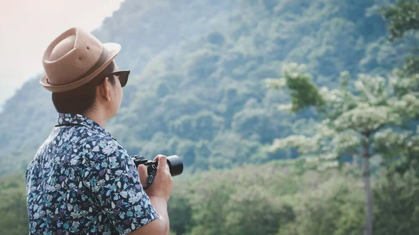 Şapkalı Güneş Gözlüklü Gezgin Adam Kamerayı Tutuyor Yeşil Arka Planda — Stok fotoğraf