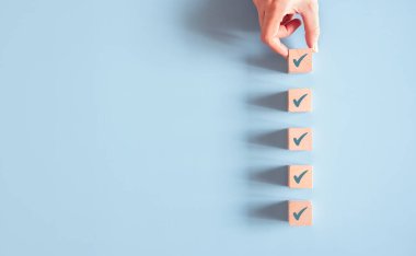 Mavi arkaplanda işaretli tahta küp, Kontrol Listesi konsepti, Boşluğu Kopyala.