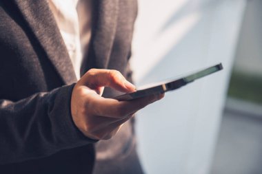 Akıllı telefon kullanan iş kadını sosyal ağda bir SMS mesajı yazıyor..