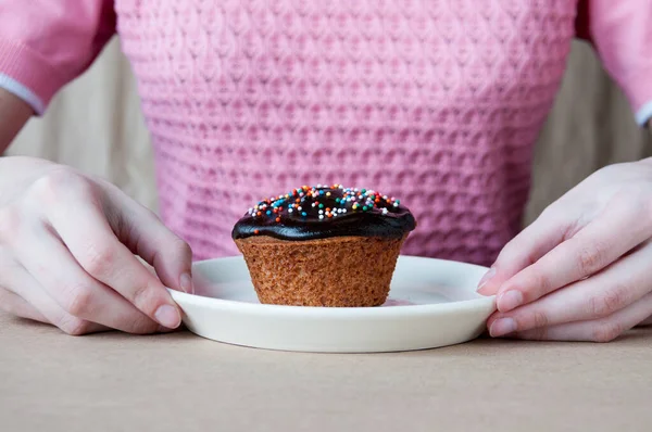 ピンクのブラウスの女の子の前にケーキがチョコレートを注いだプレートです — ストック写真