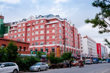 Çin, Heihe, Temmuz 2019: Büyük kırmızı bina, yazın Çin 'in Heihe şehrinin sokakları.