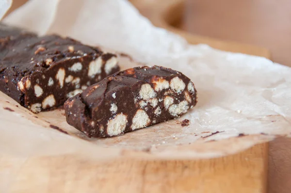 クッキーのクラムとチョコレートデザート ソーセージケーキ 紙の上に作品にカット — ストック写真