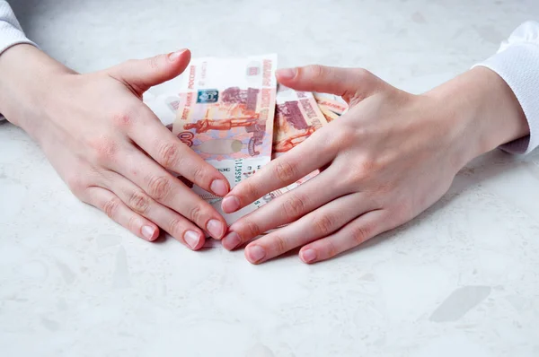 Kadınların elleri masadaki beş bin rublelik büyük banknotları korur.