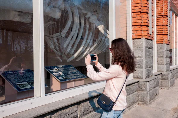 Russia, Khabarovsk, May 1, 2018: a girl takes pictures of the whale skeleton of the Khabarovsk Regional Museum. N.I. Grodekova