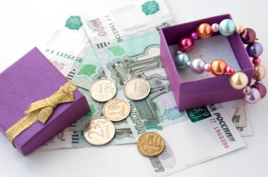 İçinde renkli inciler ve Rus parası olan bir kutu.