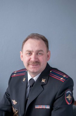 Gülümse. Polis üniformalı bıyıklı bir adamın portresi.