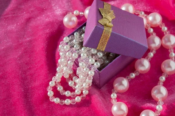 Fioletowe Pudełko Różowymi Nitkami Perłowymi Zbliżenie — Zdjęcie stockowe