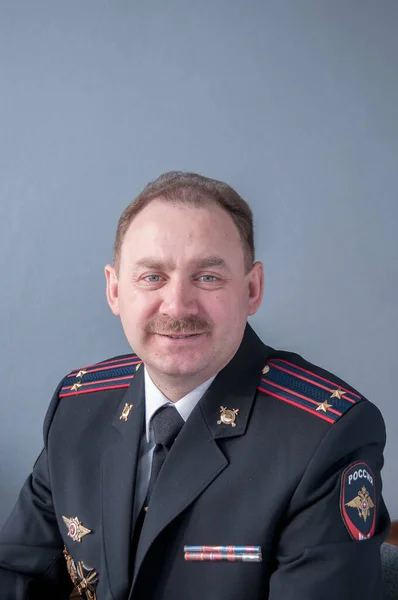 Gülümse. Polis üniformalı bıyıklı bir adamın portresi.