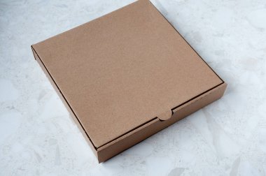 Masanın üzerinde boş bir pizza kutusu var.