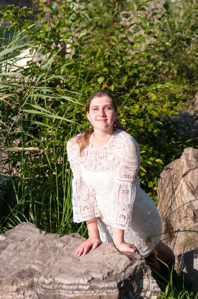 Una Chica Vestido Blanco Está Tomando Sol Una Roca Parque — Foto de Stock