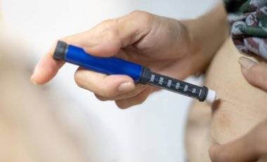 Diyabetik hasta eli evdeki şeker hastalarını kontrol etmek ve kontrol etmek için insülin kalem enjeksiyonunu kullanıyor. Sağlık ve şeker hastalığı konsepti için. 