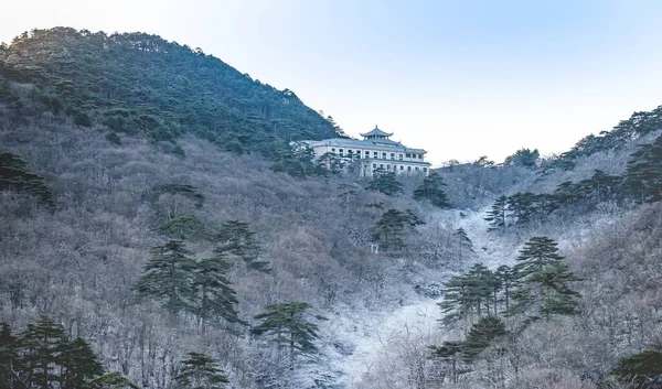 The pine tree and tourist information building covered of snow at the winter season at the Huangshan Mountain, Anhui China. View from the peak of huangshan mountain.