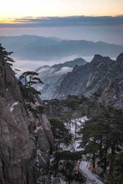 Huangshan Ulusal Parkı 'nın dağ tepelerindeki bulut ve çam ağacı manzarası. Huangshan Dağı 'nın kış mevsimi manzarası. UNESCO Dünya Mirası Alanı, Anhui Çin.