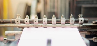 Matbaa makinesi ile fotoğraf efekti baskı üretim hattında kağıt yaprak alır, eski makine küçük reklam endüstrisi konsepti için paslı.