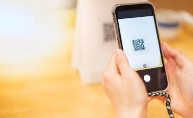 Kadın el bilgisayarı cep telefonuyla yiyecek siparişi veriyor ve yeni teknoloji e-cüzdan ve e-ödeme için restoranda ödeme yapıyor..