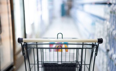 Süpermarket koridorunda boş siyah beyaz alışveriş arabasıyla bulanık etki, alışveriş yapan kişi yiyecek stoklamak için süpermarketteki Panik Alıcıyı seçiyor, Coronavirus Covid-19 konsepti.