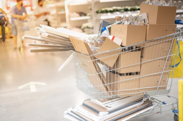 Many carton and glass bottle in the stainless trolley at Supermarket aisle preparing for arrange put on the shelves for customer to buy for decorate in house for interior concept.