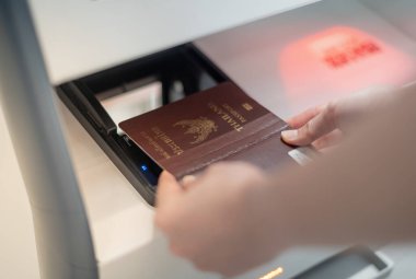 Kişisel pasaport tutan kadın havaalanı terminalinden bilet almak için self servis kontrol gişesinde tarama yapıyor..