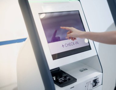 Havaalanındaki uçuş kartını almak için otomatik otomatik otomatik otomatik giriş kartını kullanan bir kadın..