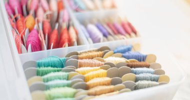 Plastik kutuda çok renkli pamuk iplikler var. El yapımı pamuk işlemeye hazır olun..