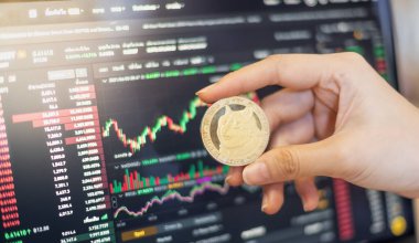 Kripto para birimiyle birlikte bir Altın Dogecoin DOGE Kripto para birimi grafiği ile ticaret yapan bir iş kadını..