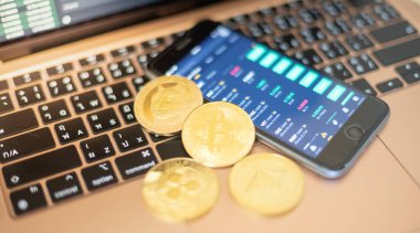 The smartphone for investors trading with the cryptocurrency coin on the laptop with a display screen and pointing on the data presented and deal on a stock exchange. clipart