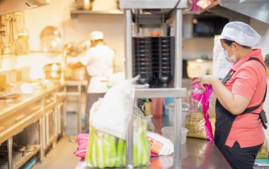 Bangkok Tayland: Haziran 04: 2021: Aşçı ve asistan restorandaki mutfakta yemek ve hizmet için malzeme hazırlayın.