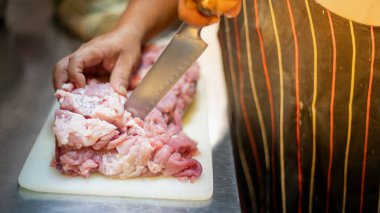 Genç erkek ellerinin yakın plan fotoğrafı taze et hazırlamak ve restorandaki müşterilere servis yapmaktır. .